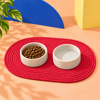 Red waxed cord dog bowl mat with two bowls on it