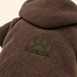 Close-up of the embroidered Cooper Project paw on brown fleece