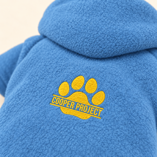 Close-up of the embroidered Cooper Project paw on denim fleece