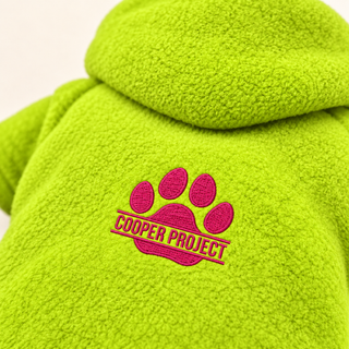Close-up of the embroidered Cooper Project paw on lime fleece