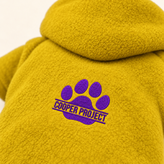 Close-up of the embroidered Cooper Project paw on mustard fleece