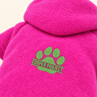Close-up of the embroidered Cooper Project paw on pink fleece