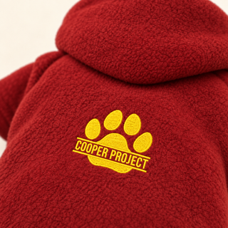 Close-up of the embroidered Cooper Project paw on red fleece